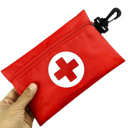 Mochila en forma de lapicera color rojo con un circulo blanco en medio que tiene una cruz, además de un lazo en negro.
