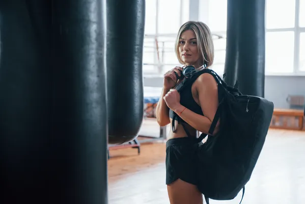 Mujer portando una mochila deportiva después de realizar su rutina de ejercicios en el gimnasio.